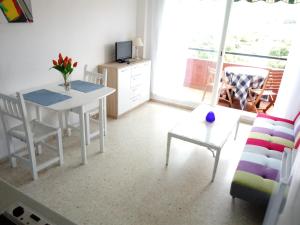 een kleine woonkamer met een tafel en een bank bij Apartamento a la Playa in Algeciras