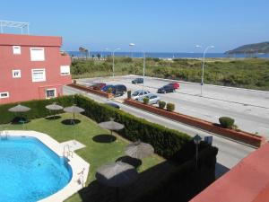 a view of a pool with umbrellas and a road at Apartamento a la Playa in Algeciras
