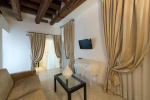 a living room with a couch and a desk and curtains at Hotel Campiello in Venice