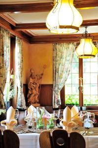 une salle à manger avec une table, des chaises et une statue dans l'établissement Hotel Prinzen, à Kappelrodeck