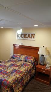 a hotel room with a bed and a sign on the wall at Atlantic Motel in Point Pleasant Beach