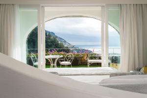 a bedroom with a view of a table and chairs at Hotel Piccolo Sant'Andrea in Praiano
