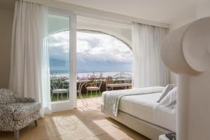 a bedroom with a bed and a view of the ocean at Hotel Piccolo Sant'Andrea in Praiano