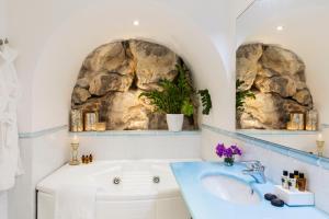 a bathroom with a sink and a rock wall at Hotel Piccolo Sant'Andrea in Praiano