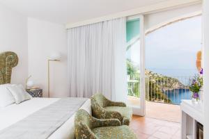 a bedroom with a bed and a view of the ocean at Hotel Piccolo Sant'Andrea in Praiano