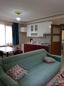 sala de estar con sofá verde y cocina en Uzungol Comfort Residence en Uzungol