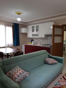 a living room with a green couch and a kitchen at Uzungol Comfort Residence in Uzungöl
