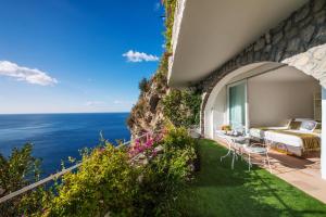 a bedroom with a view of the ocean at Hotel Piccolo Sant'Andrea in Praiano