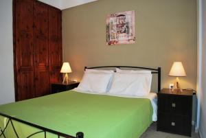 スタリスにあるKoula Apartmentsのベッドルーム1室(緑色のベッド1台、2泊用スタンド付)
