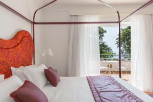 a bedroom with a bed and a large window at Hotel Piccolo Sant'Andrea in Praiano