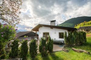 a small white house with a yard with trees at Pardellerhof Lüsen in Luson
