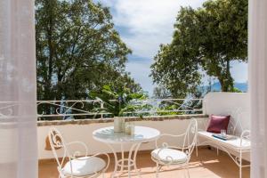 a patio with a table and chairs on a balcony at Hotel Piccolo Sant'Andrea in Praiano