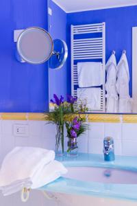 a blue bathroom with a sink and a mirror at Hotel Piccolo Sant'Andrea in Praiano