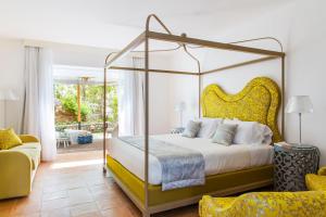 a bedroom with a canopy bed and a couch at Hotel Piccolo Sant'Andrea in Praiano