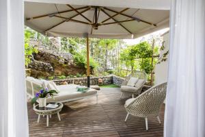 a patio with chairs and an umbrella at Hotel Piccolo Sant'Andrea in Praiano