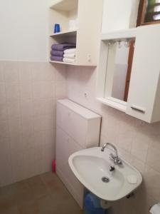 a white bathroom with a sink and a mirror at Studio apartment Zana in Ražanj