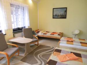 a room with two beds and a table and chairs at Maryla in Kołobrzeg