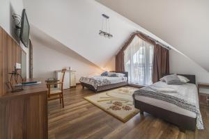 een slaapkamer op zolder met 2 bedden en een raam bij Pokoje i Apartamenty Poducha in Władysławowo
