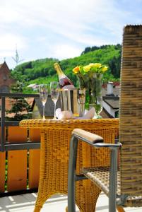 einen Tisch mit Gläsern und eine Flasche Wein auf dem Balkon in der Unterkunft Hotel Prinzen in Kappelrodeck