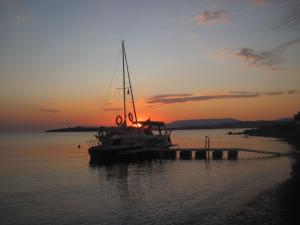 a boat is docked in the water at sunset at Bells Motel in Seferihisar