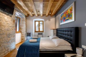 a bedroom with a large bed and a stone wall at Villa Marta in Split