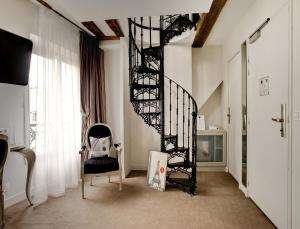 パリにあるブティック オテル コンフィダンティエルの椅子付きの客室内の黒い螺旋階段