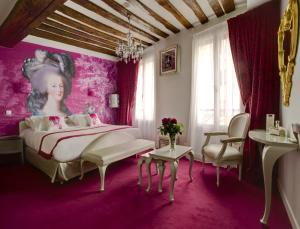 a bedroom with a bed and a painting of a woman at Boutique Hôtel Konfidentiel in Paris