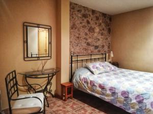 a bedroom with a bed and a mirror and a chair at El Balco del Llierca in Sant Jaume de Llierca