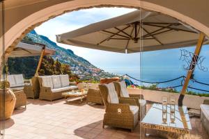 an outdoor patio with chairs and an umbrella at Hotel Piccolo Sant'Andrea in Praiano