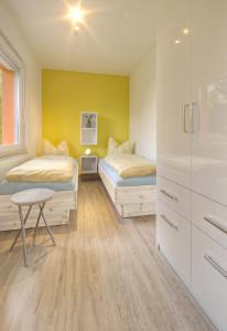 two beds in a room with yellow walls at Feriendorf am Hundsrück in Floh