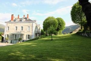 a large white house with a tree in the grass at Chateau de La Lanette in Saléchan