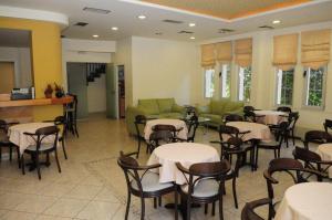 a restaurant with tables and chairs and a couch at Hotel Pantheon in Markopoulo