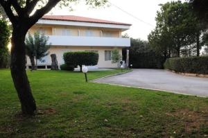 a house with a driveway in front of it at Hotel Pantheon in Markopoulo