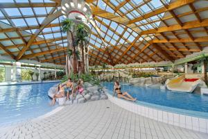 a group of people in a pool at a resort at Mobile Homes and Apartment - Terme Čatež in Čatež ob Savi