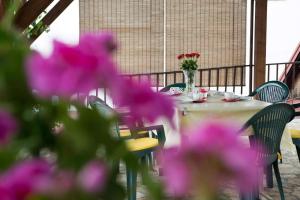 a table with purple flowers and a vase of flowers at Apartman Antea in Otočac
