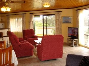 a living room with two red chairs and a television at Lake Front Motel in The Entrance