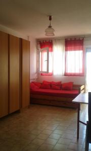 カルノン・プラージュにあるNeptuniaの窓の前に赤いソファが備わる客室です。