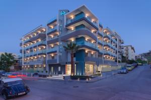 a blue building with cars parked in a parking lot at Melrose Rethymno by Mage Hotels in Rethymno Town