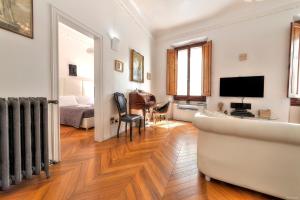 ein Wohnzimmer mit einem Sofa und einem TV in der Unterkunft Suite Deluxe Florence in Florenz