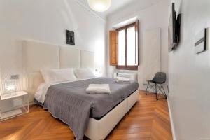 ein Schlafzimmer mit einem Bett und einem Stuhl darin in der Unterkunft Suite Deluxe Florence in Florenz