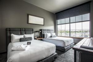 a hotel room with two beds and a window at Ironworks Hotel Indy in Indianapolis