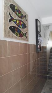 une salle de bains avec une peinture de poisson sur le mur. dans l'établissement Armação Beach Residences, à Armação de Pêra