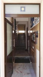 - un couloir dans un bâtiment doté d'une porte en verre et d'escaliers dans l'établissement Armação Beach Residences, à Armação de Pêra
