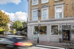 un coche conduciendo por una calle frente a un edificio en Victoria Inn en Londres