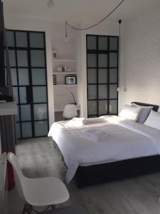a bedroom with a large white bed and a white chair at Athens View Loft - 06 in Athens