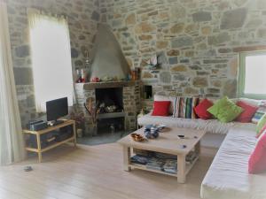 a living room with a stone wall at Serifos Vacation Home in Rámos