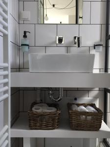 a bathroom with a sink and baskets on a shelf at Athens View Loft - 02 in Athens
