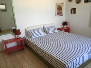 1 dormitorio con 1 cama con 2 mesitas de noche y 2 lámparas en Serifos Vacation Home en Rámos