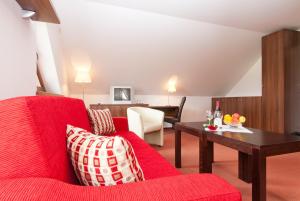 a living room with a red couch and a table at Penzion Ravence in Liptovský Trnovec