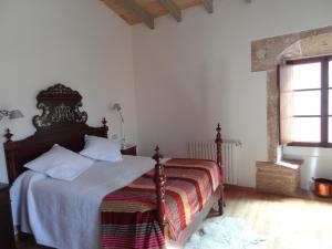 a bedroom with a bed with a striped blanket and a window at Esglesia 10 in Alcudia